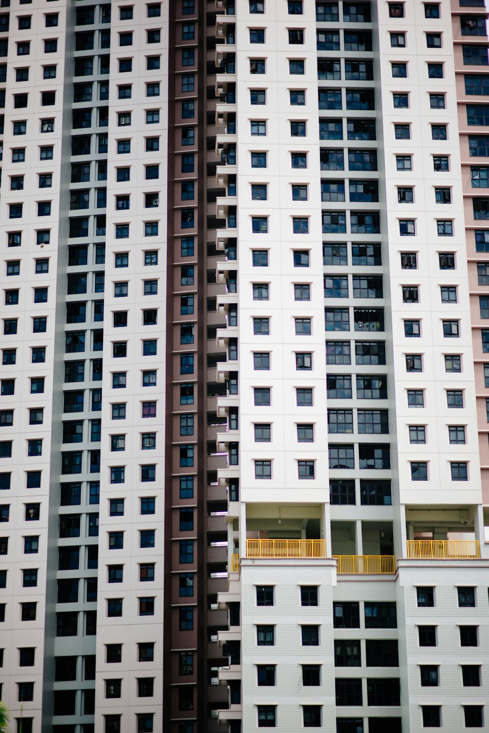 Modern residential building with white facades and yellow balconies.